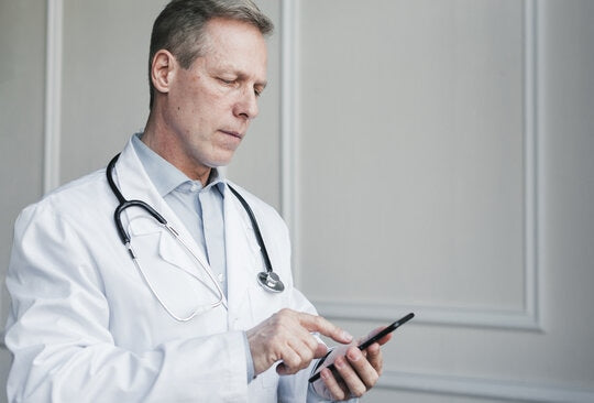 Doctor using an electronic clinical outcome assessment device during a clinical trial