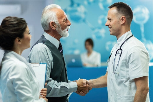 Clinical researcher shaking hands with a healthcare professional in a clinical setting