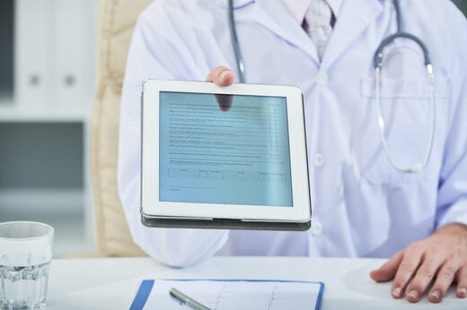 Clinician using a secure eCOA tablet to manage encrypted patient data in a healthcare setting.